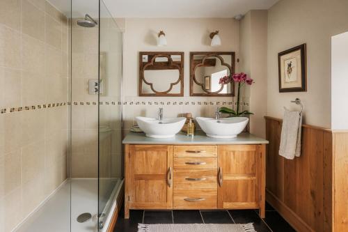 een badkamer met twee wastafels en een douche bij Meadow End Barn in Dorstone