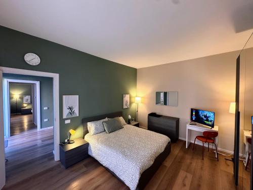een slaapkamer met een bed en een flatscreen-tv bij Le due dimore di Corso Torino in Novara