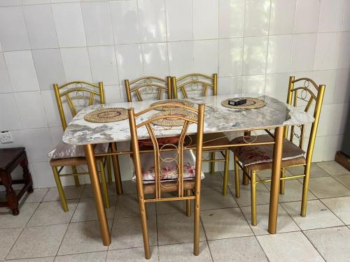 a dining room table and chairs with a marble top at Lifeline Homes in Kiserian