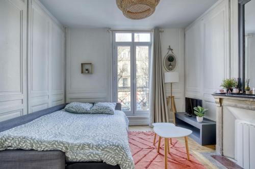 una camera da letto con un letto e una sedia di Le Belgium a Rouen