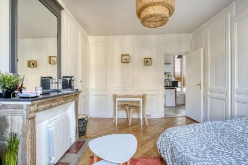 una camera da letto con un letto e una cucina con un tavolo di Le Belgium a Rouen
