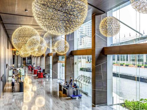 een lobby met grote kroonluchters in een gebouw bij Novotel Bangkok IMPACT in Nonthaburi