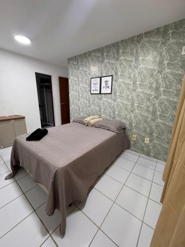 een slaapkamer met een bed en een tegelvloer bij Ap 1km da praia Araçagi in São Luís