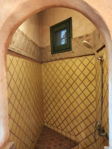 a bathroom with a shower with a tv on the wall at Chalet besides sakkara piramid in Cairo