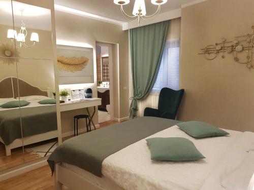 a bedroom with a bed and a desk and a mirror at Elania Residence in Târgu Jiu