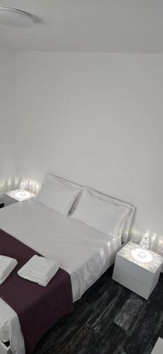 ein Schlafzimmer mit einem großen weißen Bett und einem Tisch in der Unterkunft Step by step in Scalea