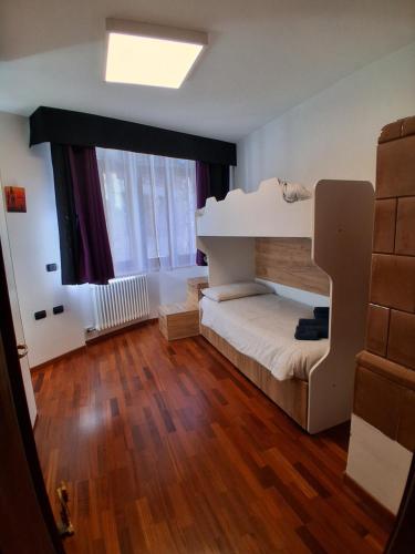 een slaapkamer met een stapelbed en een groot raam bij Appartamento a Dimaro in Val di Sole in Monclassico