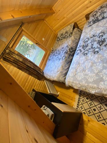 an attic room with two beds and a window at Planinska Vikendica SP Jahorina in Bistrica