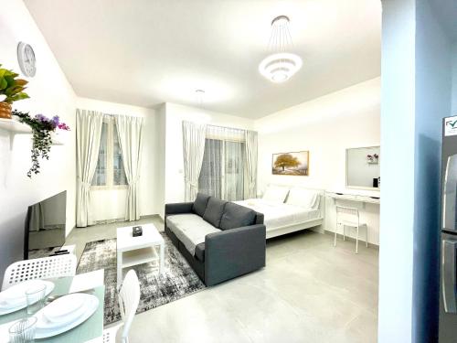 a living room with a couch and a table at Studio in International City, Newly renovated with balcony! in Dubai