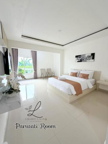 een witte slaapkamer met een groot bed in een kamer bij Lavani Living Hotel in Tjakranegara