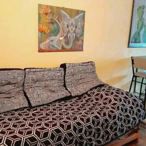 Bett in einem Zimmer mit einem Bild an der Wand in der Unterkunft Tere & Tino Cabañas in Río Ceballos