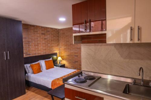 a small kitchen with a bed in a room at Hotel HK Kozy SAS in Bogotá
