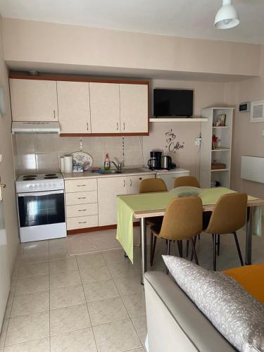 een keuken met een tafel en stoelen en een keuken met een fornuis bij Feels like home 2 in Maniákoi