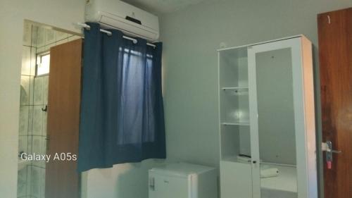 een badkamer met een blauw gordijn en een raam bij Pousada praia avenida in Maceió