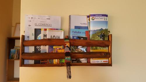 a book shelf with books on a wall at Casa Hotel Loma Wasi en Cotacachi in Cotacachi