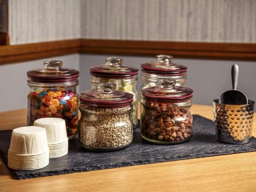 a group of jars of nuts and seeds on a counter at Mercure Livingston Hotel in Livingston