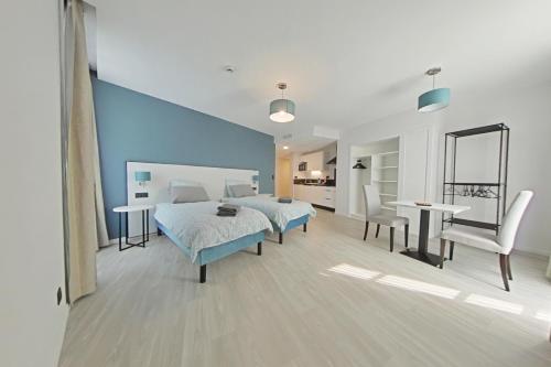 En eller flere senge i et værelse på Appart hotel Saint-Denis