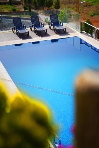 a row of chairs sitting next to a swimming pool at La Madera Resort in Turbul