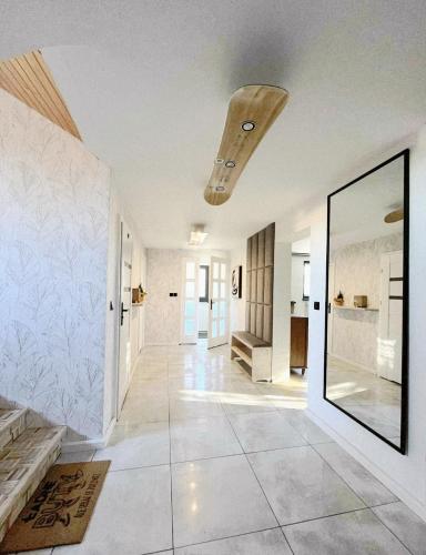 a hallway with white walls and a ceiling with a mirror at Szafran Home Spa in Korbielów