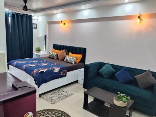 een woonkamer met een bank en een bed bij Dristy homez in Noida