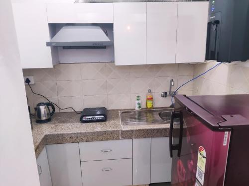 een keuken met witte kasten en een aanrechtblad bij Dristy homez in Noida