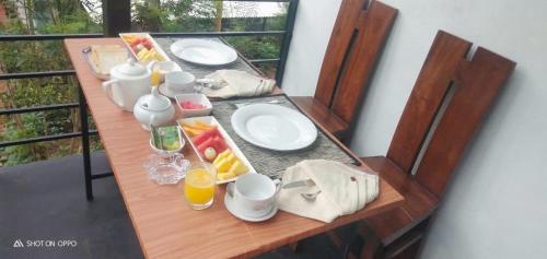 een houten tafel met borden met eten erop bij Waruna Relax Homestay in Bandarawela