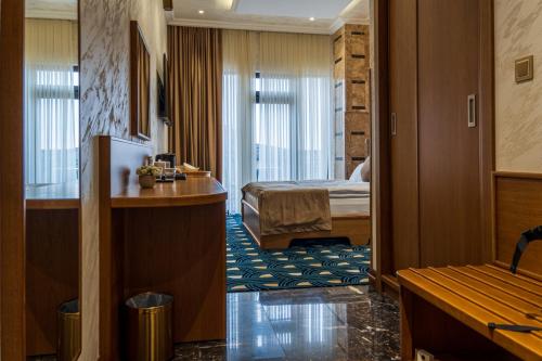 een hotelkamer met een bed en een bureau bij Hotel Aivazovsky in Gjoemri