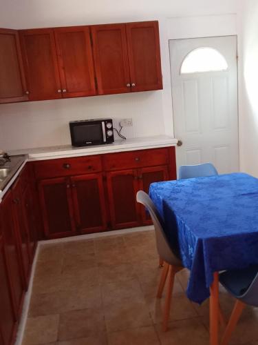 une cuisine avec une table et un chiffon bleu dans l'établissement Cassiane apartments, à Thibaud