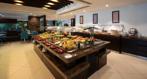 een buffet in een restaurant met veel eten bij Occidental Sharjah Grand in Sharjah