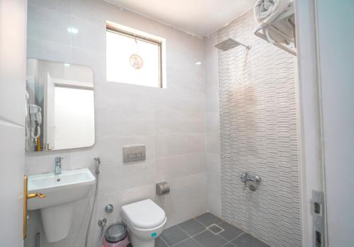 ein Badezimmer mit Toilette, Waschbecken und Spiegel in der Unterkunft Danzha Hotel 1 in Erbil