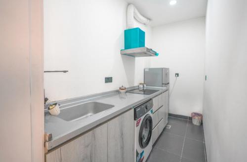 eine Küche mit Spüle und Waschmaschine in der Unterkunft Danzha Hotel 1 in Erbil