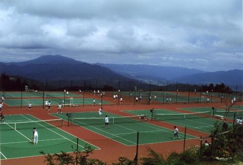 a group of people playing tennis on a tennis court at Madarao Lainstons in Iiyama