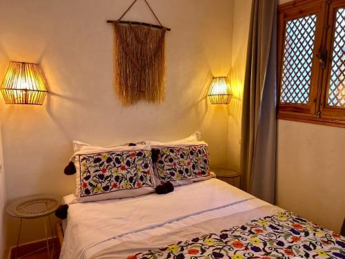 een slaapkamer met een bed met twee kussens erop bij Riad Privatisé- Riad Dar Farida in Marrakesh