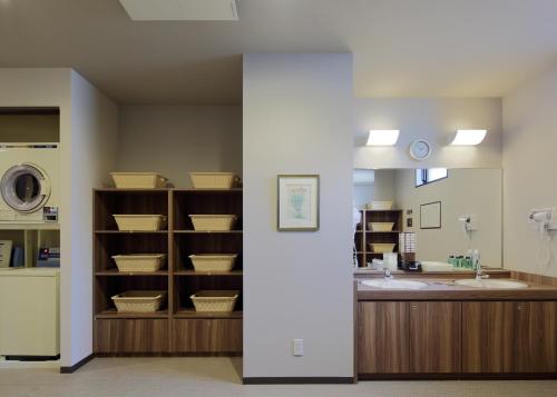 a bathroom with a sink and a counter with baskets at Hotel Route-Inn Hita-Ekimae in Hita