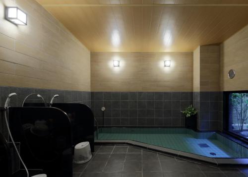 日田的住宿－日田站酒店，一间带按摩浴缸和水槽的浴室