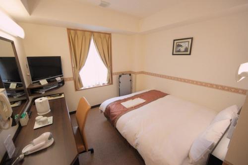 a hotel room with a bed and a desk at Life Inn Katsuta Station West in Hitachinaka