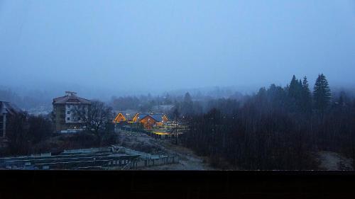 een mistig uitzicht op een stad met huizen en bomen bij Mountainview Apartment Ski, Spa & Thermal in Bansko