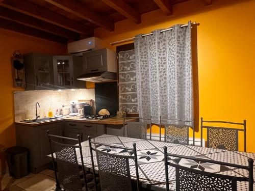 une cuisine avec une table et des chaises dans une cuisine dans l'établissement Le Jardin des Gorges, à Belvianes-et-Cavirac