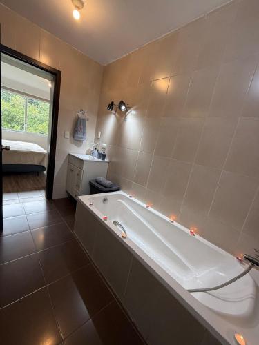 ein großes Badezimmer mit Badewanne und Waschbecken in der Unterkunft Quiet Haven Terrace with BBQ Hammock in Vilcabamba