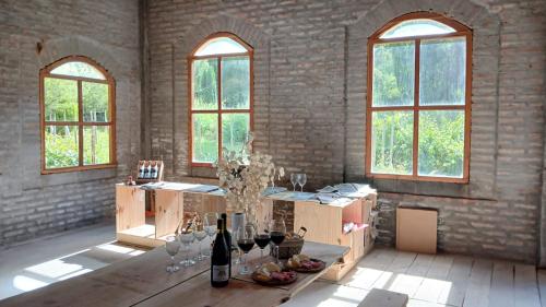a room with a table with wine bottles and glasses at Finca Fraschetti in El Bolsón