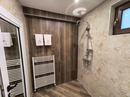 een badkamer met een douche met een glazen deur bij Карина - къща за гости in Ognyanovo