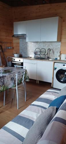 een keuken met witte kasten, een tafel en een fornuis bij Les chalets de ravine citrons in Entre-Deux