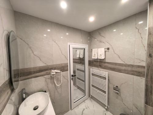 een badkamer met wastafel, douche en toilet bij Карина - къща за гости in Ognyanovo