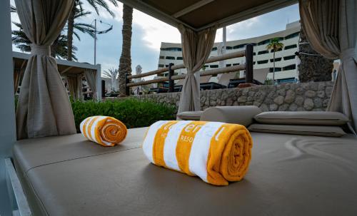 Twee oranje en witte handdoeken liggen op een bed. bij Occidental Sharjah Grand in Sharjah