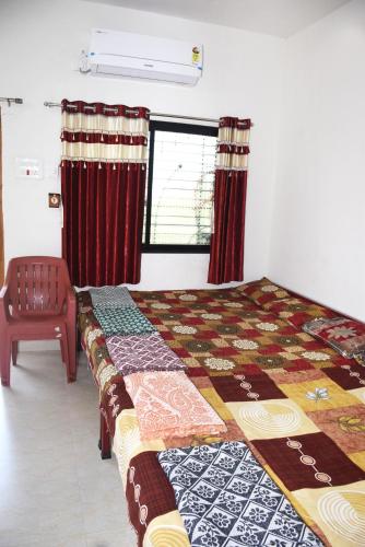 a bedroom with a bed and a window with curtains at Daneshwari Bhakt Niwas in Akalkot