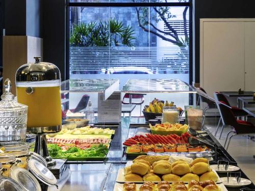 un buffet avec de nombreux types de nourriture différents exposés dans l'établissement ibis BH Afonso Pena Savassi, à Belo Horizonte