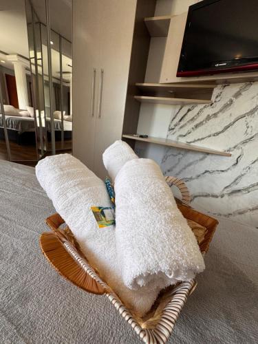 two towels sitting on a basket in front of a tv at Refúgio da Lagoa in Florianópolis