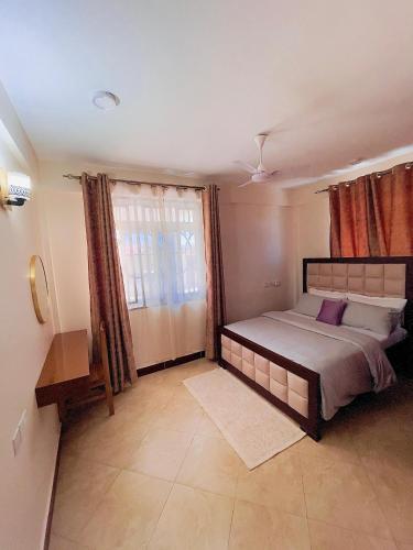 a bedroom with a large bed and a window at Lucia Homes & Stays in Dodoma