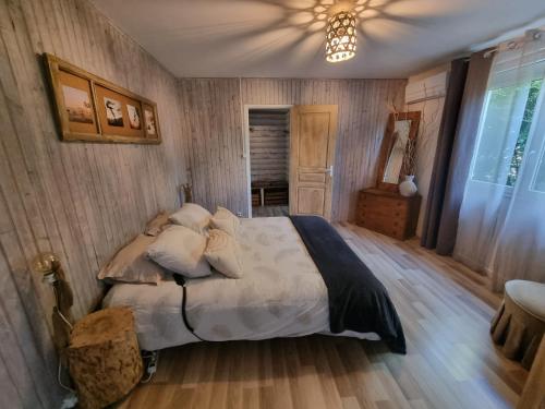 ein Schlafzimmer mit einem Bett und einer Decke in der Unterkunft Plume in Cazaubon