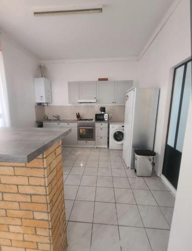 una cucina con elettrodomestici bianchi e pavimento piastrellato di T2 de 70 m2 au cœur de Sète a Sète
